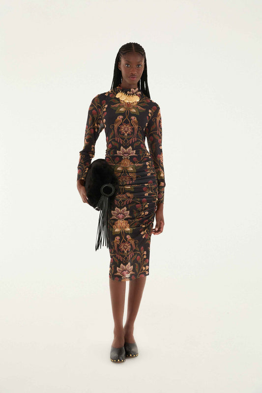 Woman wearing a long sleeve patterned dress with a white background